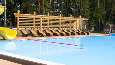 Kompleks basenowo-rekreacyjny w Powsinie. Leżaki pod pergolami. Kompleks basenowo-rekreacyjny w Powsinie.