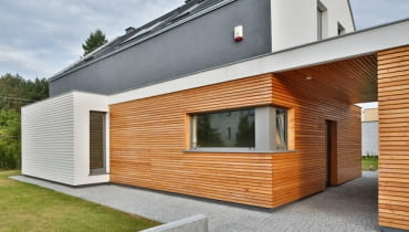 Pomimo ukrycia wejścia głównego do domu pod zadaszeniem, w przejściu pomiędzy budynkami, ukształtowanie bryły budynku jednoznacznie wskazuje jego lokalizację dom jednorodzinny, dom zdjęcia, domy zdjęcia, domy realizacje, elewacje domów