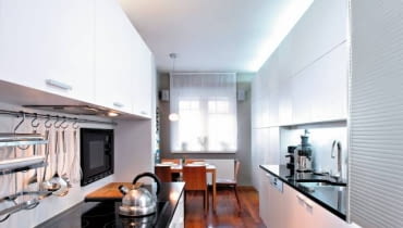 Projektowanie wnętrz. Kuchnię zabudowano dwoma ciągami pojemnych szafek. Miejsce pod oknem przeznaczono na kąt jadalny. Ciekawym rozwiązaniem jest metalowa roleta zasłaniająca pion instalacyjny. WNETRZA , KUCHNIA