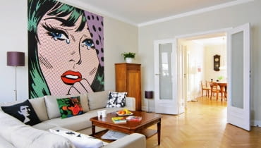 Pan Marcin jest zdeklarowanym miłośnikiem modernizmu. Mieszkanie w łódzkiej kamienicy z lat 30. XX wieku odnowił, dbając o każdy zachowany detal. Dzięki współczesnym dodatkom wystrój zyskał szczyptę pikanterii. Trzeba naprawdę dużo wyczucia, by różne elementy tak do siebie dopasować! <BR /> MIESZKANIE. Ulubionym kolorem gospodarza jest biel - i to ona dominuje w całym mieszkaniu. Urządzanie pokoju dziennego zaczęło się od przyklejenia fototapety z reprodukcją popartowskiego plakatu autorstwa Roya Lichtensteina, amerykańskiego malarza i grafika bardzo cenionego przez pana Marcina. Szafka z początku XX wieku (w rogu) to nabytek z aukcji internetowej.