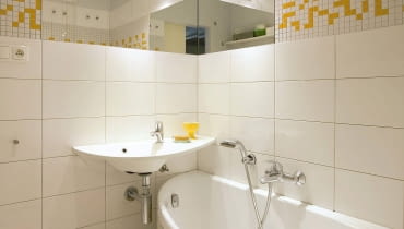 NAROŻNA UMYWALKA ma kształt, który umożliwia zainstalowanie jej nad węższą częścią wanny. Pod umywalką nie da się, niestety, umieścić szafki, ale jej poszerzony blat można wykorzystać jako półkę na kosmetyki.