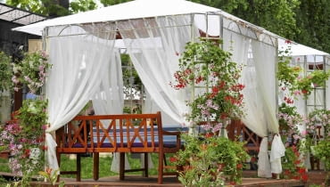 Zadaszony ogrodowy pawilon wsparty na metalowej konstrukcji daje cień ogrodowym biesiadnikom Zadaszony ogrodowy pawilon wsparty na metalowej konstrukcji daje cień ogrodowym biesiadnikom