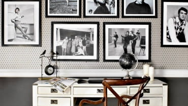 Galeria może ożywić pomieszczenie barwami albo też podkreślić jego oszczędną, stonowaną kolorystykę - tak jak te czarno-białe fotografie wyeksponowane w stylowym kąciku do pracy. Galeria zdjęć, ramki do zdjęć, wieszanie obrazów
