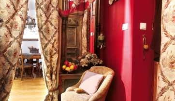 Ścianę oddzielającą przedpokój od pokoju dziennego usunięto, a w szerokim przejściu powieszono kotarę z podwójnie złożonej grubej tkaniny. Ścianę oddzielającą przedpokój od pokoju dziennego usunięto, a w szerokim przejściu powieszono kotarę z podwójnie złożonej grubej tkaniny.