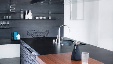 Początków tego stylu należy szukać w Bauhausie. Ta szkoła projektowania, działająca w latach 1919-1933 w Weimarze i Dessau, dała początek popularnemu do dziś w architekturze i wnętrzarstwie funkcjonalizmowi. Idee twórców Bauhausu, wyrażane między innymi w hasłach: 'mniej znaczy więcej' oraz 'forma wynika z funkcji', designerzy z końca lat osiemdziesiątych XX wieku powiązali z niechęcią do zbytku i oszczędnością kolorystyczną. Tak powstał minimalizm. Stylowi temu rządzącemu wzornictwem przez ponad dwadzieścia lat, wielu krytyków zarzucało, że odziera wnętrza z ciepła i indywidualizmu. Ale chociaż na początku XXI wieku minimalizm ustąpił miejsca bardziej dekoracyjnym trendom, nadal ma licznych zwolenników. <BR > Style. Elegancka prostota jest widoczna nawet w kuchniach. Zabudowie dodają urody zróżnicowane materiały. Meble firmy Schiffini, proj. Vico Magistretti. 10.02.2012 WARSZAWA SESJA WNETRZE , STYLE NA ZDJECIU WNETRZE , LAZIENKA , SALON , SYPIALNIA STYLIZACJA ANETA KOSIBA DLA CZASOPISMA CZTERY KATY FOT. ARKADIUSZ SCICHOCKI / AGENCJA GAZETA SLOWA KLUCZOWE: SESJA STYLE