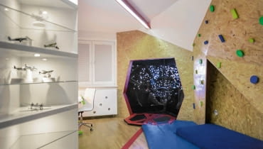 PO ZMIANIE. Linię podziału między strefami o różnym przeznaczeniu wyznacza długa lampa LED (zrobili ją samodzielnie rodzice chłopców) i naklejony na podłogę pas z tworzywa sztucznego. Pas ten prowadzi do kabiny Sokoła Millenium wchodzącego w nadprzestrzeń (a mówiąc bardziej przyziemnie - do wnęki oklejonej fototapetą). pokój dziecięcy, meble dziecięce, metamorfoza pokoju dziecięcego