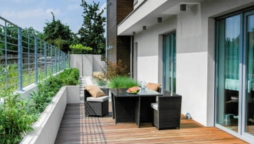 Mały ogród z dużym tarasem. WIDOK OGÓLNY TARASU. Na posadzce z drewna egzotycznego ustawiono nowoczesne meble z praktycznego technoratanu. Mały ogród z dużym tarasem.