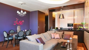 W mieszkaniu Kamili i Rafała konsekwentnie zestawiono fiolet z&#8200;dębem barwionym na&#8200;wenge. Uwagę zwraca jednak nie&#8200;tylko przemyślany dobór&#8200;kolorów i materiałów. Popatrzmy również na funkcjonalne rozwiązania zaproponowane przez projektantkę. <BR /> MIESZKANIE. Różne odcienie fioletu pojawiają się zarówno w kuchni, jak i w pokoju dziennym. W tym kolorze jest m.in. szklana mozaika chroniąca ścianę nad zlewozmywakiem (zainstalowanym przy wysokiej zabudowie z jasnej płyty MDF) oraz tapeta w kącie jadalnym. Spod szafek nad zlewem i zza podwieszonego sufitu sączy się nastrojowe światło emitowane przez taśmy LED.