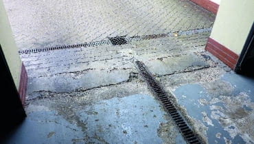 Zniszczona podłoga w garażu pomalowana farbą chlorokauczukową