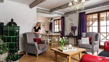 <B>Sielska okolica i architektura polskiego dworku skłoniły Agnieszkę i Wiesława do urządzenia domu w tradycyjnym stylu. Nie trzymali się jednej konwencji aranżacyjnej. Pomieszali wiejskie klimaty ze skandynawską prostotą i pałacowym szykiem. Efekt - wnętrza odbiegające od sztampy, ciepłe i ponadczasowe.</B> <BR />Pokój dzienny z aneksem jadalnym wygląda tak, jakby służył już kolejnemu pokoleniu mieszkańców. Takie wrażenie wywołują wiekowe belki stropowe pozyskane z rozbiórki dwustuletniego spichlerza oraz wystrój skomponowany z mebli o różnym rodowodzie. Chociaż eklektyczna konsolka, angielskie fotele uszaki i 'chłopskie' stoły zasadniczo różnią się stylem, razem tworzą harmonijną całość. dom, salon, aranżacja salonu, belki na suficie