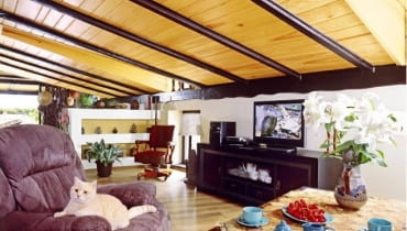 Sufit, obłożony sosnowymi deskami, podtrzymują belki z bejcowanego dębu. Sufit, obłożony sosnowymi deskami, podtrzymują belki z bejcowanego dębu.