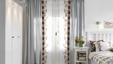 <B>Ze względu na swą prostą formę, panele zasłonowe, zwane też ekranami, idealnie pasują do nowoczesnych wnętrz. Ale w tradycyjnych też się odnajdą, zwłaszcza w towarzystwie ozdobnych zasłon.</B> <BR />Efektowny nadruk ludowego haftu zdobiący tkaninę mógłby stać się mało czytelny, gdyby udrapowano ją w fałdy albo suto umarszczono. Z materiału uszyto więc panele zasłonowe. Dzięki temu motyw jest dobrze widoczny. Takie same wzory jak na panelach widnieje na pościeli. Razem tworzą bardzo wysmakowaną dekorację wnętrza. Panel zasłonowy, 60 x 300 cm - 59,99 zł, IKEA.