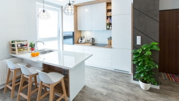 Jasna kolorystyka i zwarta zabudowa dodają kuchni nowoczesnego wyrazu. 65-metrowe mieszkanie w Kielcach