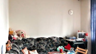 POKÓJ PRZED ZMIANĄ. Na rozkładanej narożnej kanapie spały razem mama i córka. Obok przy małym biurku Magda odrabiała lekcje. Stolik kawowy przy kanapie służył również jako stół jadalny.