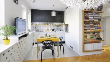 Kropka na ogół wieńczy dzieło, w tym wnętrzu je rozpoczęła. Wypatrzone w sklepie płytki z takim motywem stały się źródłem inspiracji dla projektantki, która urządzała mieszkanie swojej przyjaciółki. <BR /> MIESZKANIE. Pas ściany nad kuchennym blatem wykończono płytkami ceramicznymi. Nad nimi zamocowano płytę gipsowo-kartonową pokrytą tapetą w dyskretny kwiatowy deseń. Pod płytą schowano przewody gazowe i oświetlenie blatu. Zamiast szafek wiszących - tylko prosta półka fornirowana dębem. Nietypowa zabudowa znajduje się w centrum mieszkania. Od strony kuchni są w niej pojemne szafki, piekarnik i lodówka, ze strony pokoju dziennego - regał, a część przedpokojowa mieści pralkę ze schowkami. kuchnia, meble kuchenne, aranżacja małej kuchni