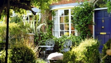 W tym maleńkim ogródku, gdzie mieszczą się zaledwie dwa krzesła, nastrój tworzą pnącza