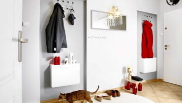 <B>Gdy pieniędzy jest mało, zakupy trzeba zastąpić wyobraźnią i zręcznością rąk. Tak właśnie zrobiła projektantka i właściciele prezentowanego przedpokoju. Efekt: efektowny, a do tego oryginalny wystrój wnętrza.</B> <BR />PO ZMIANIE. Aby optycznie powiększyć przedpokój, ściany pomalowano na dwa odcienie jasnej szarości (barwa ta ma właściwość oddalania się od patrzącej osoby). Wieszaki na wierzchnie ubrania dopasowano do minimalistycznego stylu wnętrza. Nowe jest również lustro i oświetlający je kinkiet z dekoracyjnym abażurem ze szklanych wisiorków. Do dość ascetycznego wnętrza trochę ciepła wprowadza puszysty dywan. Poza tym zakrywa nieładne połączenie płytek i drewnianych paneli. m