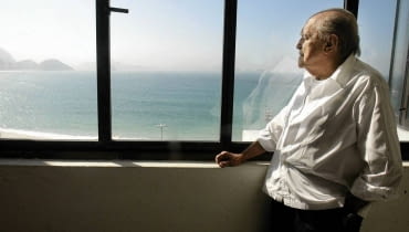 Niemeyer patrzy na Copacabanę z okna swojego biura. Zdjęcie z 2003 roku Brazilian architect Oscar Niemeyer looks at the Copacabana beach from his office after his interview with Reuters in Rio de Janeiro, in this June 16, 2003 file photo. Niemeyer, a towering patriarch of modern architecture who shaped the look of contemporary Brazil and whose inventive, curved designs left their mark on cities worldwide, died late on December 5, 2012. He was 104. Niemeyer had been battling kidney and stomach ailments in a Rio de Janeiro hospital since early November. His death was the result of a lung infection developed this week, the hospital said, little more than a week before he would have turned 105. REUTERS/Sergio Moraes/Files (BRAZIL - Tags: OBITUARY SOCIETY)