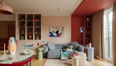 W tym mieszkaniu kolor nie jest dodatkiem, lecz pełnoprawnym bohaterem, który kreuje przestrzeń pełną emocji. Na zdjęciu niebieska sofa to model marki Optisofa, a stojąca niebieska lampa producenta Aldex. Na niebieskim stoliku ze sklepu Jotex wyeksponowano wazon Nana Malwiny Konopackiej. Honorowe miejsce nad sofą zajmuje obraz Agnieszki Pietrzykowskiej.