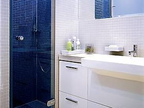 5,2m2 <br> Wannę i murowany natrysk bez brodzika (woda spływa po nachylonej podłodze do kratki ściekowej) umieszczono przy jednej ścianie. Szerokość (52 cm) szklanych drzwi kabiny tak dobrano, by nawet przy pełnym otwarciu nie uderzały o umywalkę. Po drugiej stronie łazienki zmieścił się tylko sedes, więc zamiast bidetu zamontowano baterię bidetową. Na ścianach, podłodze, obudowie wanny i prysznica ułożono gładką mozaikę w dwóch kolorach. Ciemnymi kafelkami wykończono te miejsca, które mają wydawać się oddalone LAZIENKA STYLIZACJA DOROTA KARPINSKA FOT. ALEKSANDER RUTKOWSKI PUBLIKACJA CZTERY KATY NR 11 (146) - 11.2003 DO JEDNORAZOWEJ PUBLIKACJI