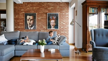 Do nowoczesnego salonu atmosferę zasiedzenia wprowadzają stare meble, jak biblioteczka i fotel-uszak. aranżacja wnętrza ze starymi meblami