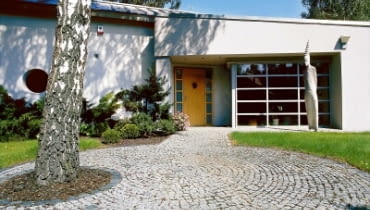 Wejścia do domu strzeże dwumetrowy totem. Drewniane drzwi - poszerzone i podkreślone wnęką ładnie kontrastują z aluminowymi elementami wykończenia budynku. UWAGA ! PONOWNA PUBLIKACJA ZA ZGODA WLASCICIELI !