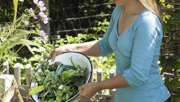 Frau schuettet Kuechenabfaelle auf den Kompost61053298SLOWA KLUCZOWE:draussen Sptsommer hoch Garten Praxis Person msgnp12 000 Biogarten GEMSEGARTEN Bauerngarten