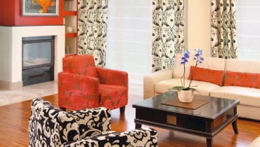 Ani minimalistyczny, ani zbyt nowoczesny, ani też umeblowany wyłącznie starociami. Właściciele marzyli o domu urządzonym inaczej niż mieszkania znajomych czy te pokazywane w pismach. Zestawiając przedmioty o różnym rodowodzie, stworzyli wnętrze naprawdę niebanalne. <BR /> DOM. Czerwień, na jaką pomalowano ścianę kominka, powtarza się na innych elementach wystroju - na poduszkach, abażurach i obiciu jednego z foteli. Kolorystykę wnętrza urozmaicają także akcenty czerni, m.in. na lnianych zasłonach i na drugim fotelu.