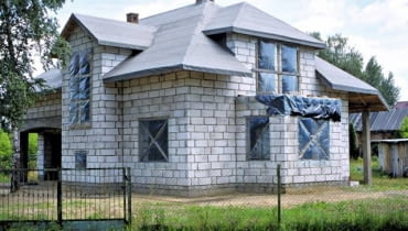 Dom w stanie surowym otwartym, dobrze przygotowany do zimy: dach przykryty jest papą na deskowaniu, otwory okienne zasłonięte folią Fot. Rafał Polak-Kuchta