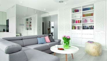 Lustrzane fronty sprawiły, że wielka szafa (w której oprócz półek ukryto pralkę oraz wysuwany kosz na pranie) nie przytłacza wnętrza, a wręcz przeciwnie - dodatkowo je powiększa. Taflą lustra wyłożono też bok wysokiej zabudowy kuchennej stykającej się z szafą. Lampę nad stolikiem kawowym właścicielka znalazła na aukcji internetowej. Tkaninę naciągnięto na metalowy stelaż; wieczorem, gdy jest włączone światło, abażur przypomina - zdaniem Małgorzaty - talerz z delikatnej porcelany. LUSTRZANE FRONTY sprawiły, że wielka szafa (w której oprócz półek ukryto pralkę oraz wysuwany kosz na pranie) nie przytłacza wnętrza, a wręcz przeciwnie - dodatkowo je powiększa. Taflą lustra wyłożono też bok wysokiej zabudowy kuchennej stykającej się z szafą. Lampę nad stolikiem kawowym właścicielka znalazła na aukcji internetowej. Tkaninę naciągnięto na metalowy stelaż; wieczorem, gdy jest włączone światło, abażur przypomina - zdaniem Małgorzaty - talerz z delikatnej porcelany.