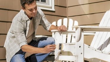 01ANDB86 Portrait of man painting deck chair DATE TAKEN: 41246 SLOWA KLUCZOWE:
