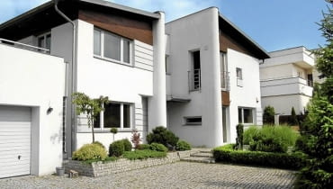 Widok na dom od strony wjazdu, wejście ukryte we wnęce Dom jednorodzinny projektu architekta Janusza Kaczorka
