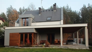 Widok od strony ogrodu. Zadaszenie nad samochodem jednocześnie ochrania przed słońcem i deszczem taras prowadzący do salonu realizacje domów, domy zdjęcia, dom jednorodzinny