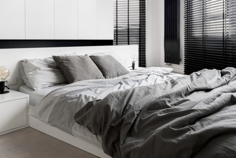 Czerń we wnętrzu - żaluzje, grzejnik na ścianie, fragment zabudowy meblowej