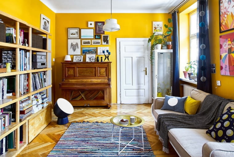 STYL LAT SZEŚĆDZIESIĄTYCH podkreśla m.in. szafka, która stała w gabinecie lekarskim w dawnym przedszkolu dzieci Marii. Dzisiaj zdobią ją wracające do łask bluszcze i monstery. Charakteru dodają wnętrzu również odratowane oryginalne drzwi. Pianino to spadek po cioci męża, uczą się na nim grać dzieci. Kubek i miska na stoliku są ze sklepu ? Tab.