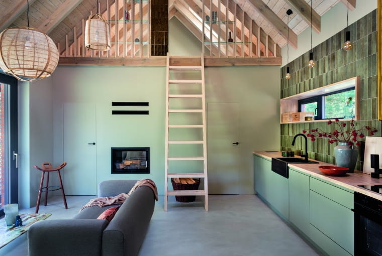 Zgodnie z założeniem projektowym centralnym punktem wnętrza jest dwustronny kominek, który nie tylko grzeje, ale i wprowadza do wnętrz wspomniany wcześniej symboliczny ogień. W rogu inny symbol – hiszpańskiego designu z lat 70. XX wieku: hoker Marbella