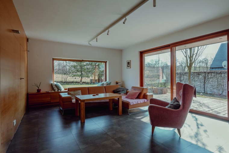 Salon, czyli fragment otwartej części dziennej, którą uzupełnia kuchnia z jadalnią. Oprócz tego na parterze znajdują się: łazienka, siłownia i pomieszczenia gospodarcze. Na piętrze usytuowano zaś sypialnię rodziców, dużą łazienkę oraz pokoje córki i syna