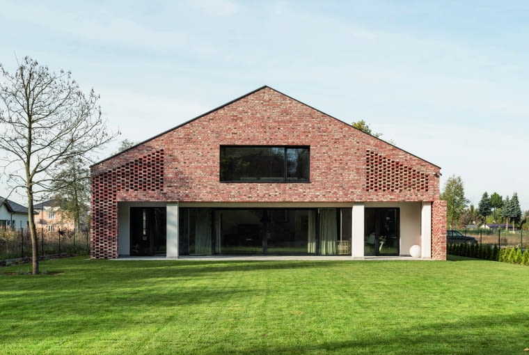 Projekty domów-stodół czasem inspirowane są najlepszą  lokalną architekturą, która wdzięcznie znosi upływ czasu.   Takim przykładem są stare, poniemieckie budynki,  wniesione na bazie cegieł. Dzięki temu nowo powstały  obiekt idealnie wpisuje się w okoliczny kontekst