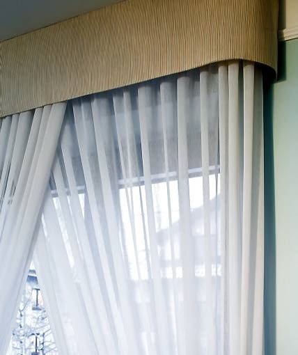 DEKORACJE - OKNO W ZWIEWNYM PRZYBRANIU. Sztywny lambrekin przylegający bokami do ściany zrobiono z grubszej tkaniny niż firanki. Jej barwa nawiązuje do koloru obicia tapicerowanych mebli.