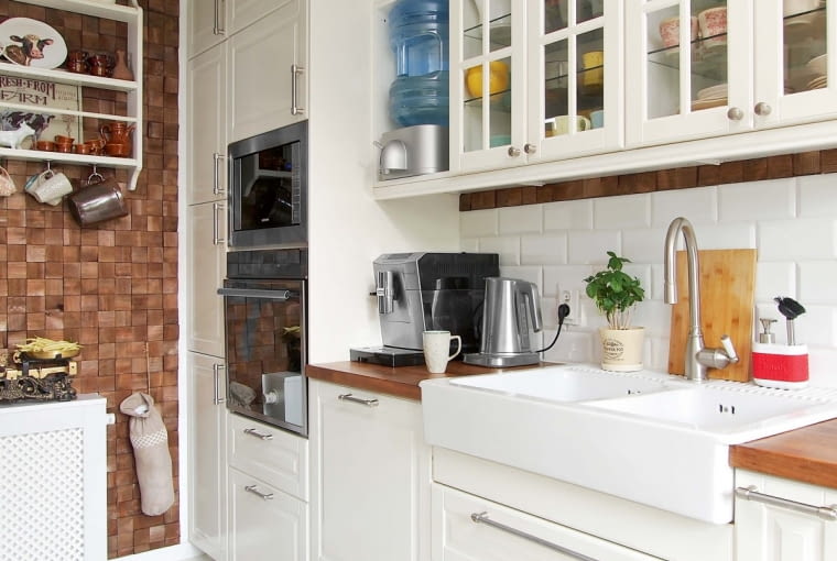 Wyrazistym akcentem jest położona na ścianie w głębi oryginalna wykładzina z przeplatanych pasków ciemnego drewna (Castorama). Ściany nad blatami wyłożono prostokątnymi białymi płytkami (Opoczno).