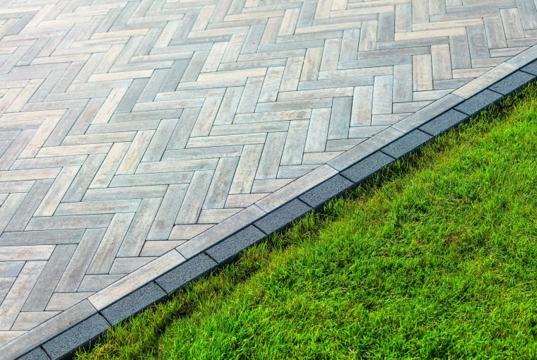 Kostka świetnie nadaje się do budowy nawierzchni przed nowoczesnymi budynkami. Poza klasycznym ułożeniem naprzemiennym może być także układana w modny wzór jodełki