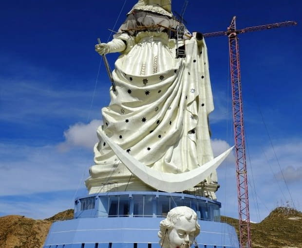 People work at the base of the Virgin of the Socavon (patron saint of miners) statue during its construction at the Santa Barbara hill in the outskirts of the Oruro, some 200 km (124 miles) south of La Paz, January 18, 2013. The statue measures 45 metres (148 feet) in height and stands at 3850 meters (12,631 feet) above sea level. The statue is expected to complete by February 2, 2013 according to its sculptors. REUTERS/David Mercado (BOLIVIA - Tags: RELIGION SOCIETY)