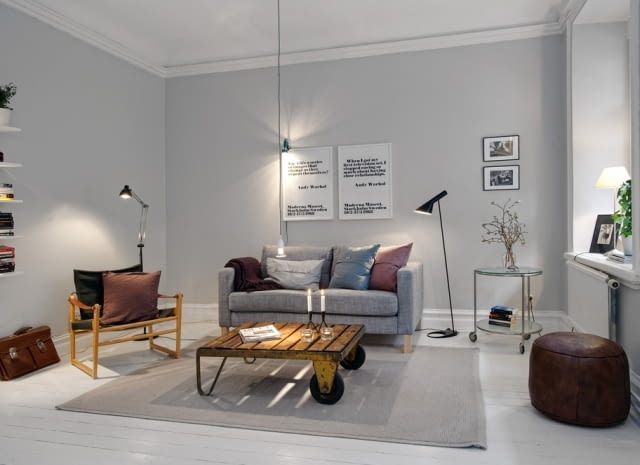 Salon w stylu skandynawskim. Industrialny stolik przełamuje sterylność pomieszczenia. Salon w stylu skandynawskim