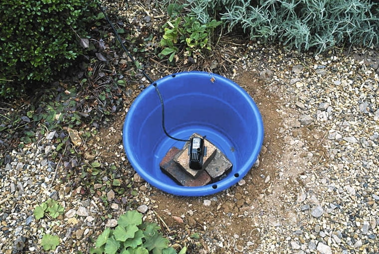 źródełko WATER FEATURE STEP-BY-STEP: PUMP PLACED ON TOP OF BRICKS INSIDE THE BLUE PLASTIC BUCKET SLOWA KLUCZOWE: 000 BLUE BRICKS BUCKET FEATURE FOUTAIN INSIDE PLACED PLASTIC PUMP STEP-BY-STEP TOP WATER draussen quer Sommer Stepabfolge Praxis Gr ser Kiesgarten Kies Wasserspiel Wasser Eimer blau Plastik Pumpe Beet Garten