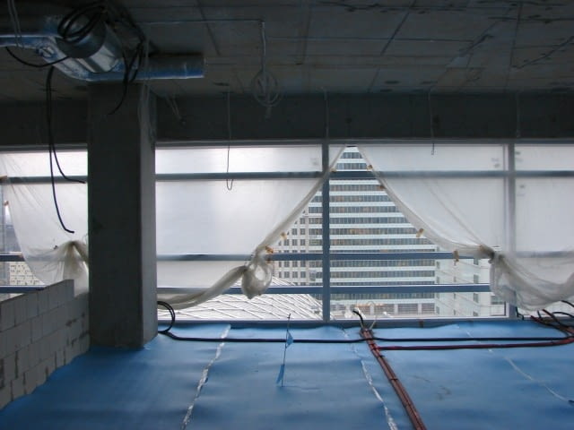 Okna w północnej elewacji. Za nimi widok na wieżowce warszawskiego city.