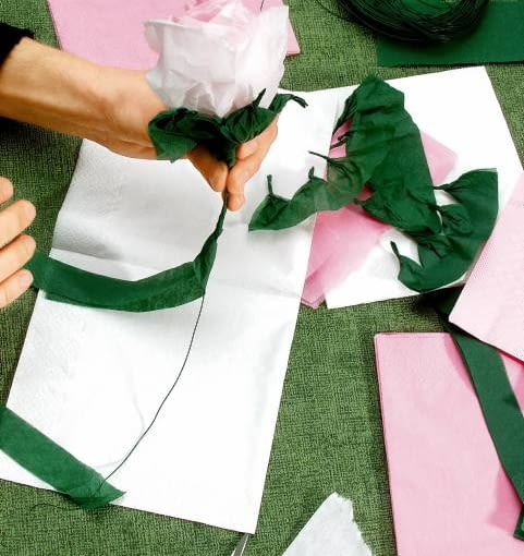 W RÓŻANYM OGRODZIE - ZRÓB TO SAM. 6. Paskiem z zielonej serwetki (szer. 2 cm) owijamy szypułkę i łodygę. Końce paska przyklejamy, by się nie rozwijał. DEKORACJE ROZA Z BIBULKI WYKONANIE