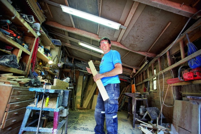 GOSPODARZ w swojej pracowni stolarskiej. Właśnie pracuje nad szafą w stylu góralskim, która stanie w jadalni.