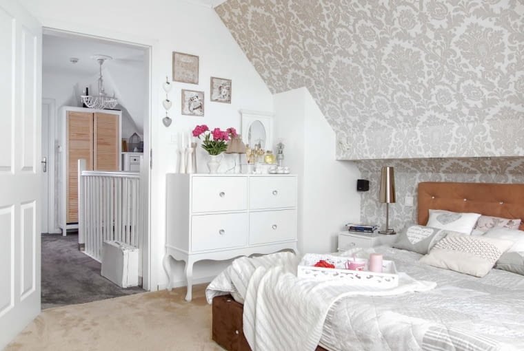 Tapeta w sypialni (z Obi) to dowód na przejściowe zauroczenie gospodyni stylem glamour. Na tapicerowanym łóżku leżą poduszki i narzuta ze sklepów home&you oraz Netto. Szafki do sypialni wykonała pracownia SM Sylwia Morzuch.