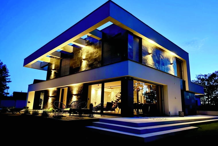 Inwestorzy chcieli mieć dom z płaskim dachem i mają – przynajmniej w widoku z kilku stron – np. tu od ogrodu. Jednocześnie w tej „nieistniejącej” przestrzeni jest miejsce na przechowywanie rozmaitości...