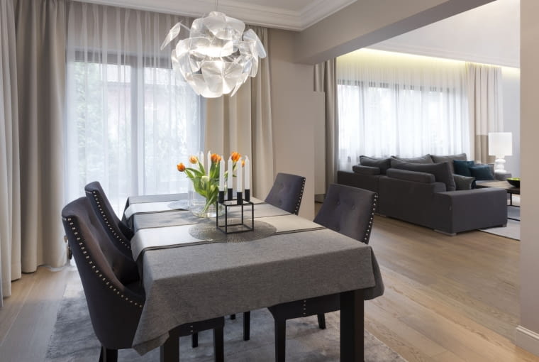 Salon i jadalnia są oddzielone szerokim przejściem. Minimalizm z nutą glamour w domu we Włocławku